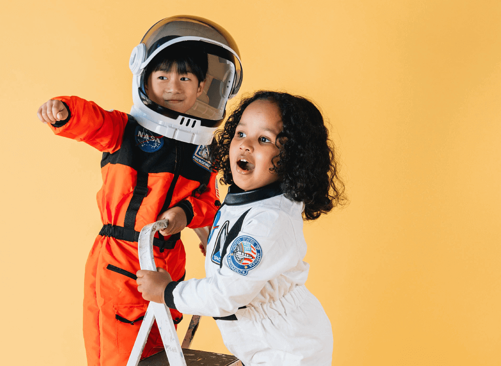 children dressed as astronauts standing on a ladder